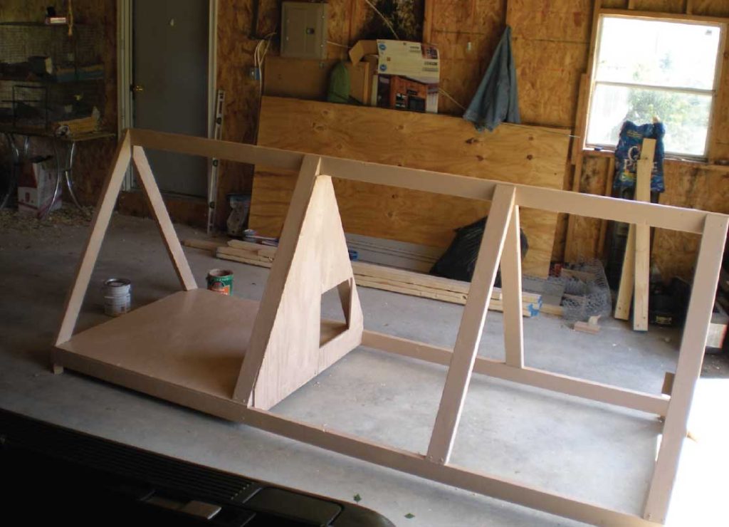 The frame of the poultry ark being built. A wooden framed tripod/pyramid structure.
